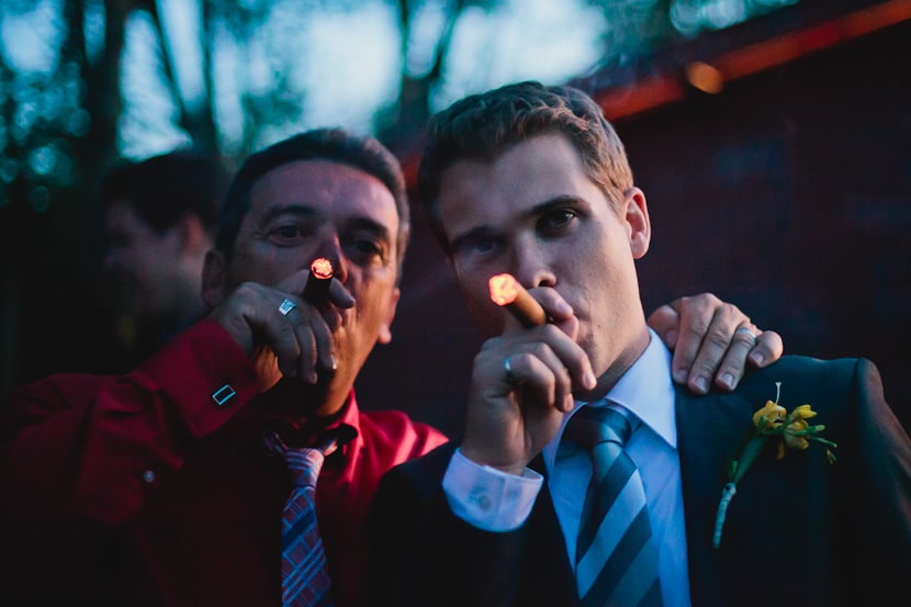 groom and father share celebratory cigar