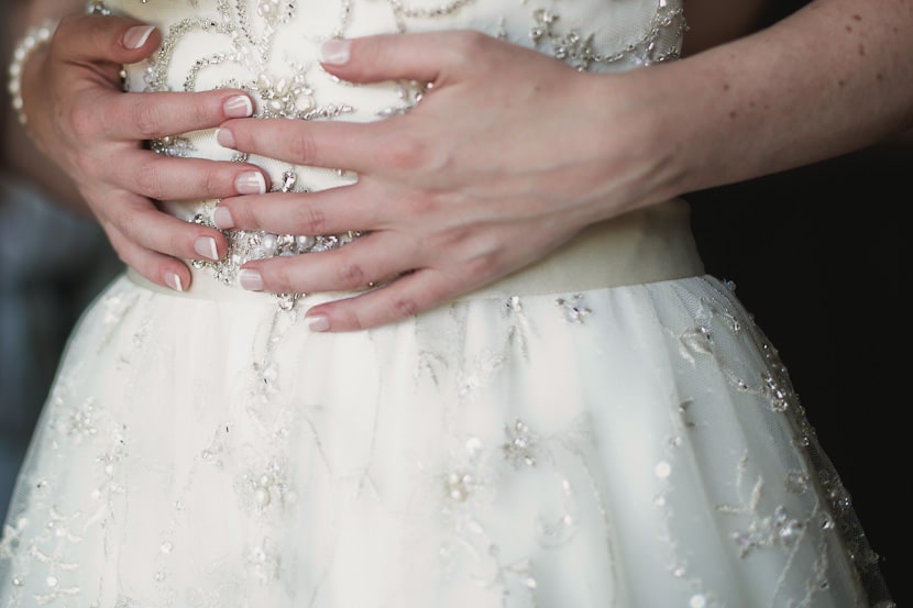 brides hands on wedding dress