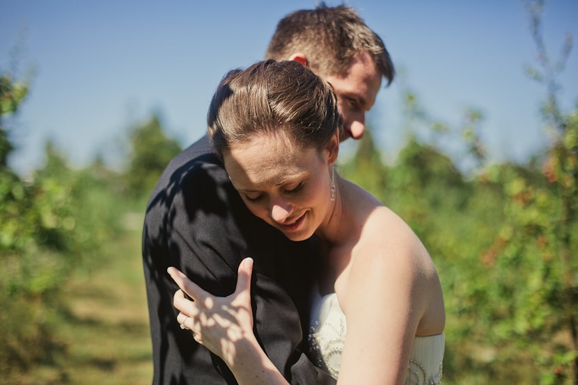 bride and groom hugging at sea cider apple orchard