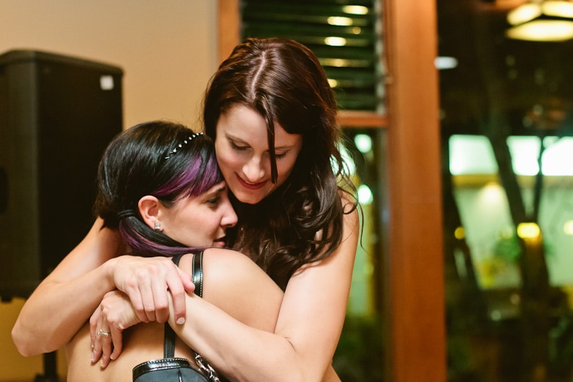 bride hugging friend after wedding reception