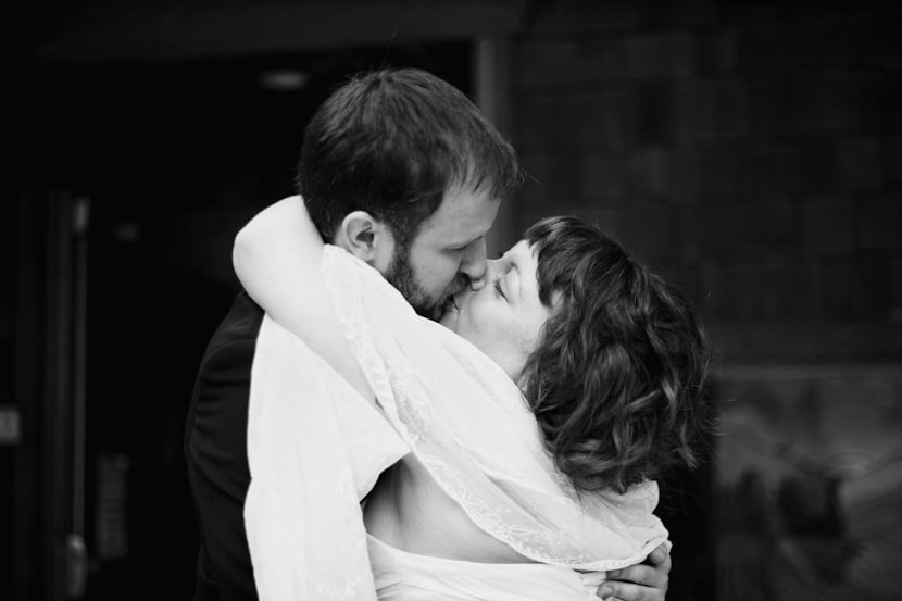 couple kisses after wedding ceremony outside pender islands community hall