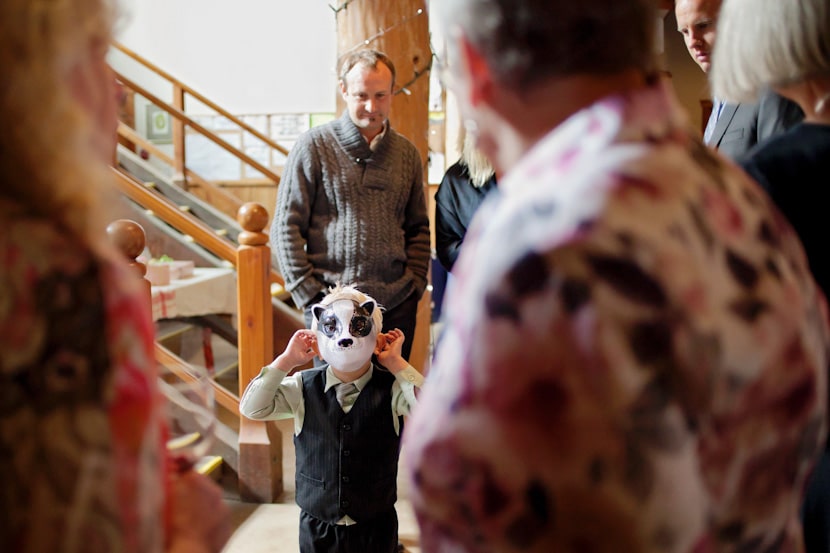 child wearing badger animal mask at wedding reception