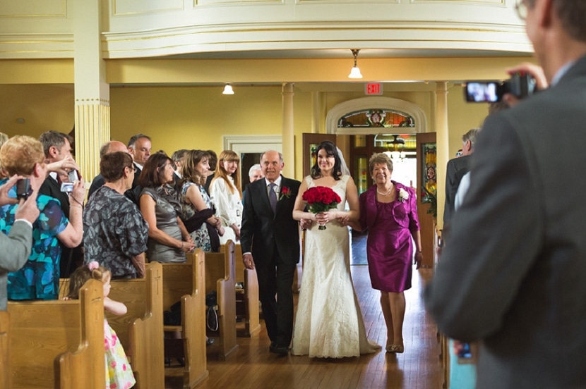 bride being walked down aisle by mother and father at St. Ann's