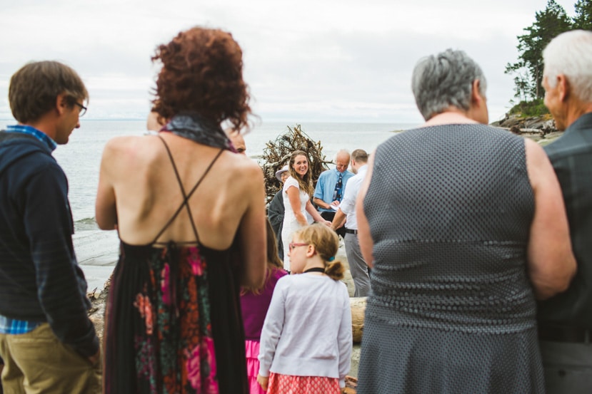 The bride sends a loving glance to family and friends from the beachfront ceremony