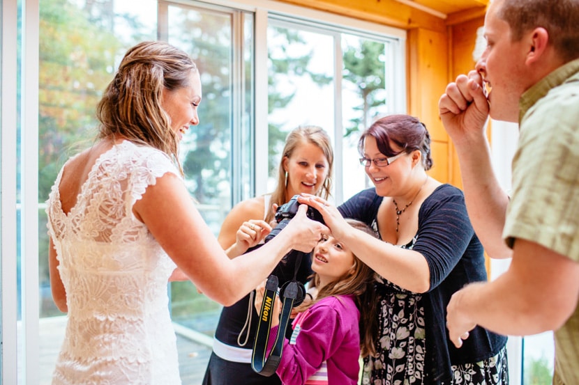 The lace detail of the wedding gown is on full display as the bride chats with guests.