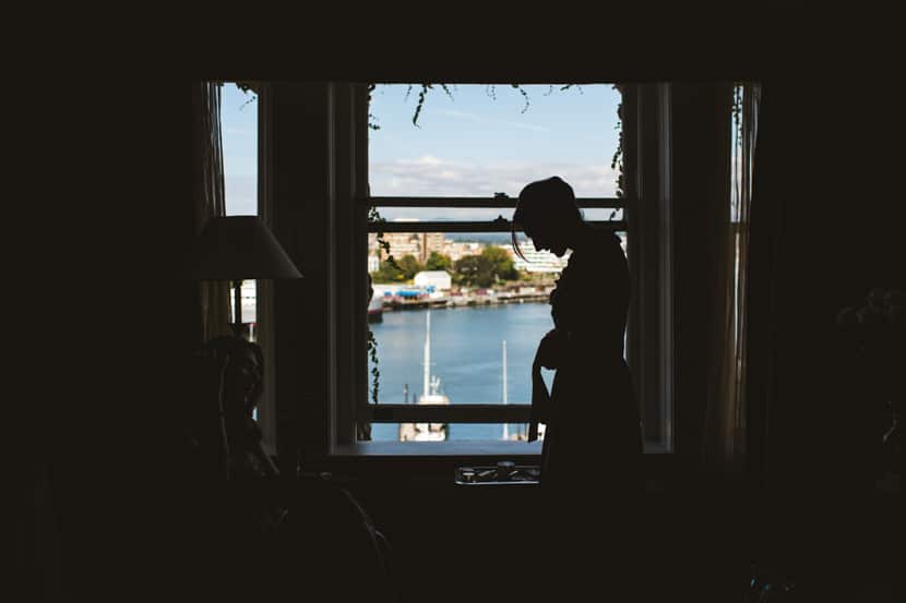 silhouette of bride getting dressed at fairmont empress hotel