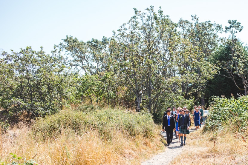 wedding party walks through woods before wedding ceremony