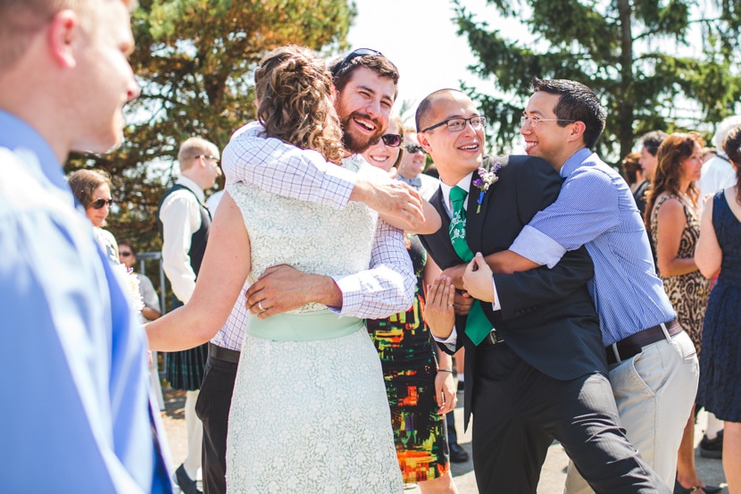 couple hugs friends after wedding ceremony