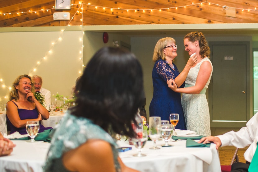 bride and mother share emotional moment at wedding reception