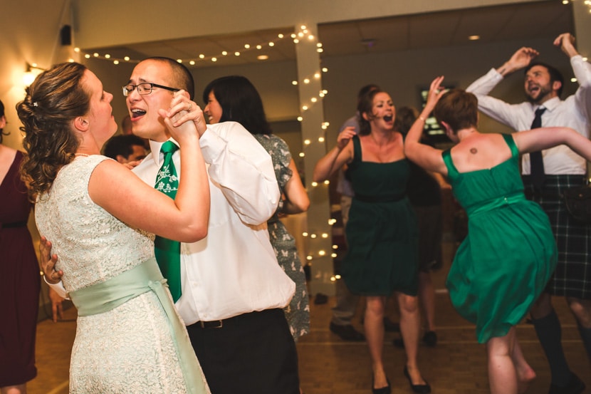 bride and groom and wedding party dance energetically