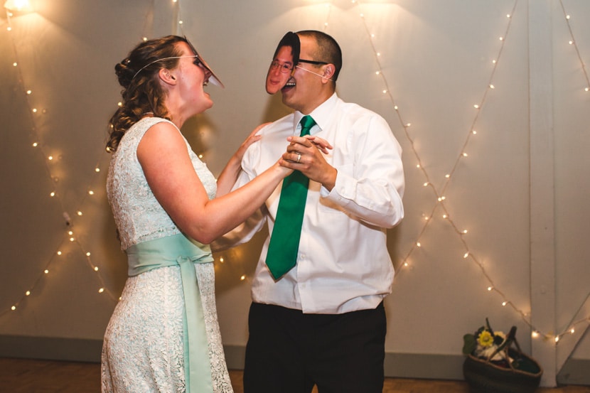 bride and groom dancing with groom masks