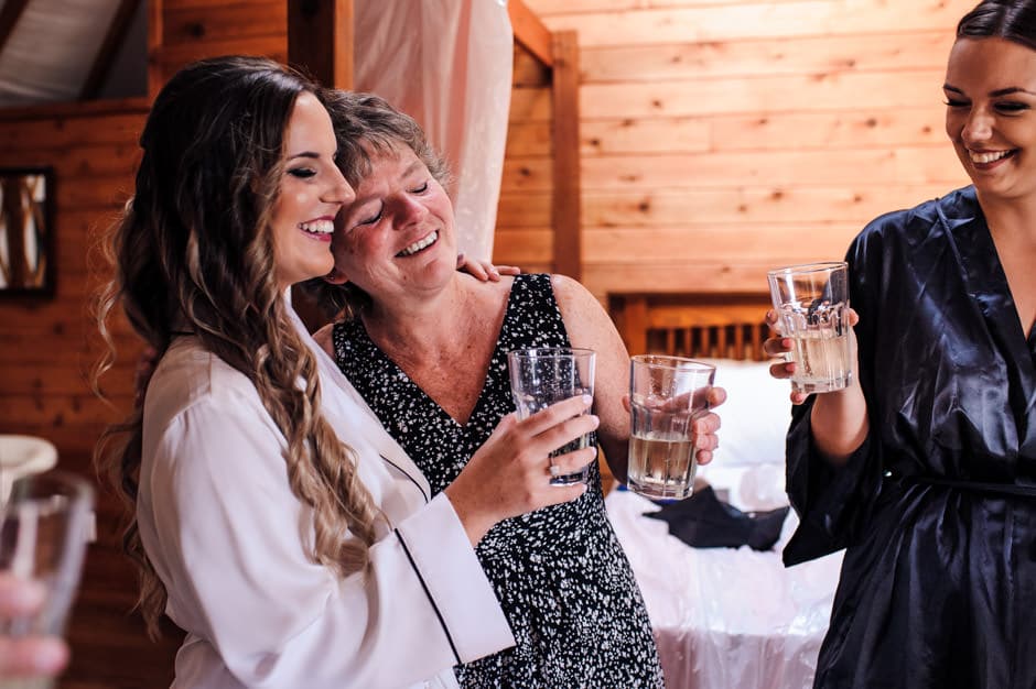 bride and mother hugging during pre-ceremony toast