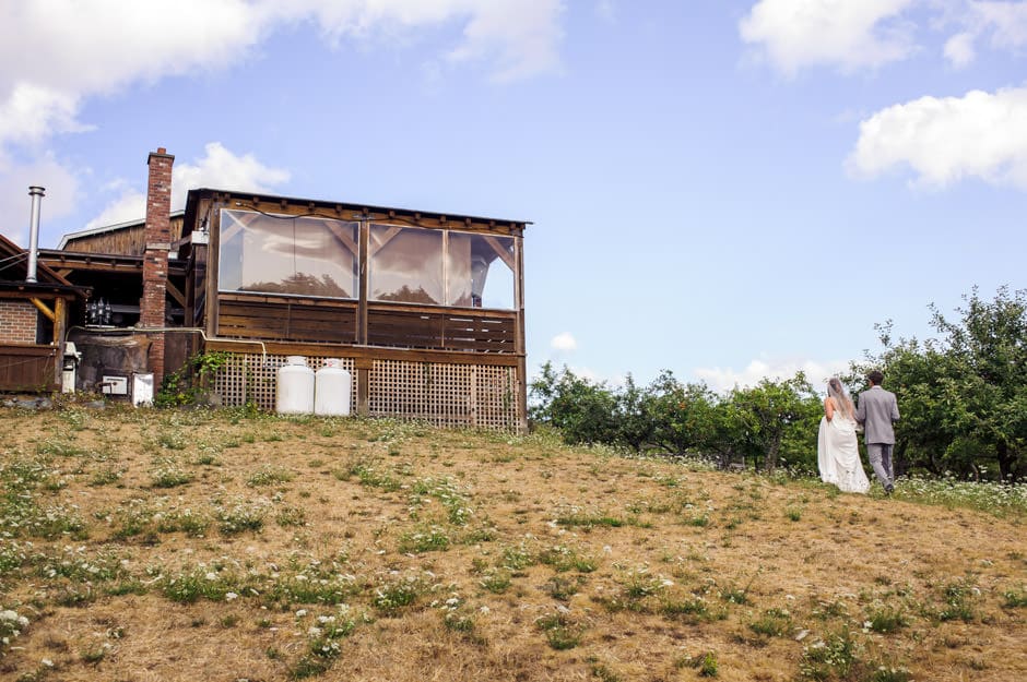 bride and groom walking by ciderhouse at merridale