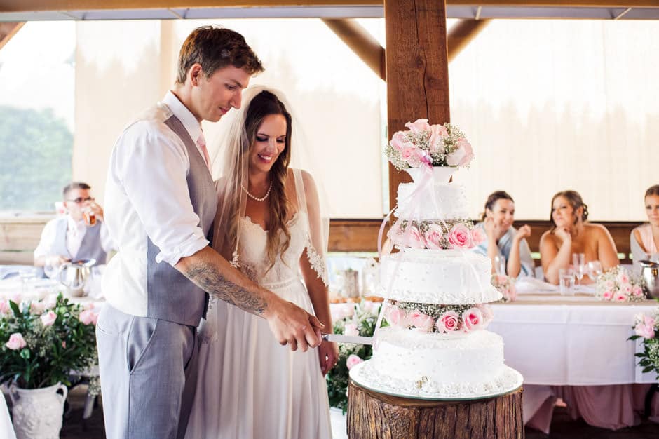 couple cutting homemade cake at wedding reception