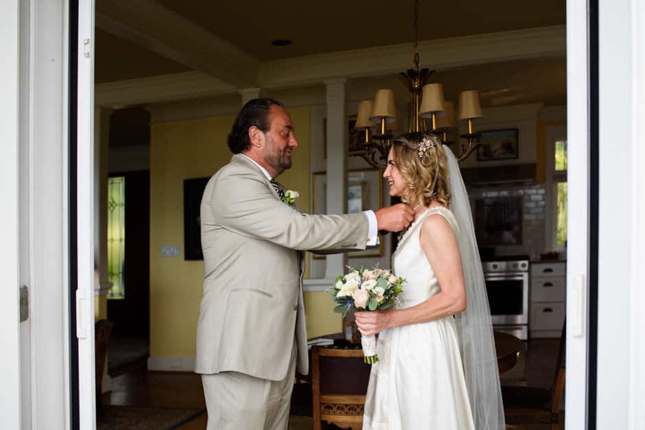 bride's friend helping her get ready for wedding in house at Deep Cove Chalet