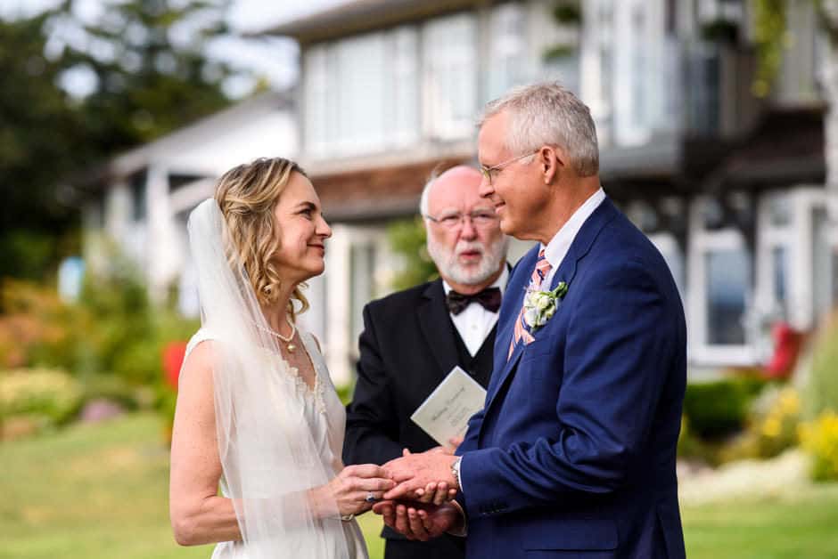 couple exchanging rings during outdoor wedding ceremony