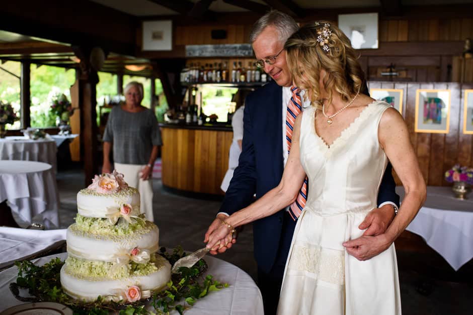 bride and groom cutting floral wedding cake