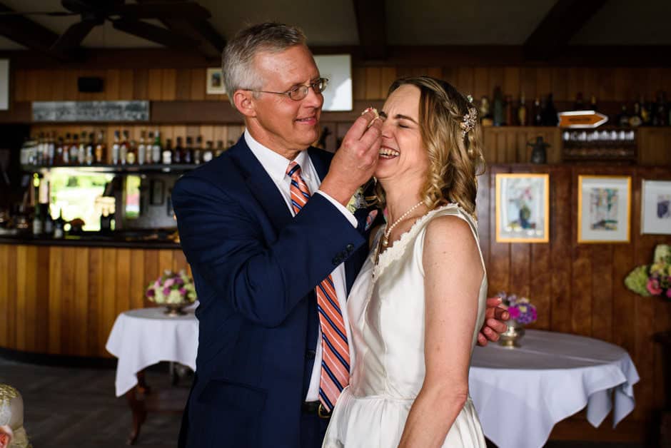 groom threatening to smush cake on bride's face