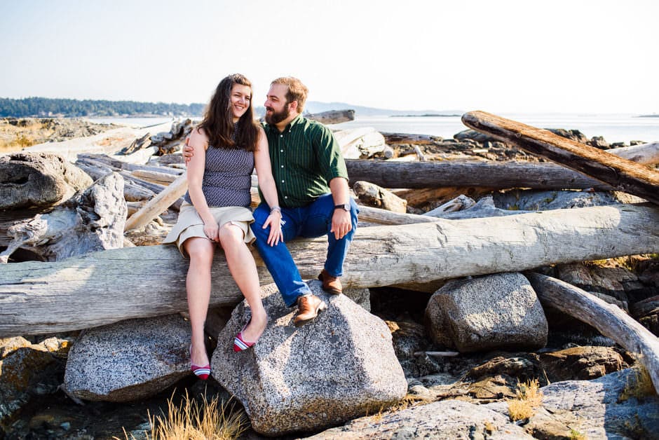 couple sitting on driftwood at cattle point