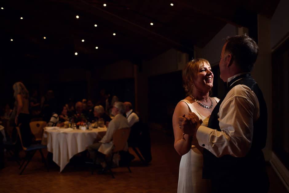 bride and groom slow dancing among lights