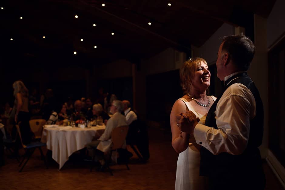 bride and groom slow dancing among lights