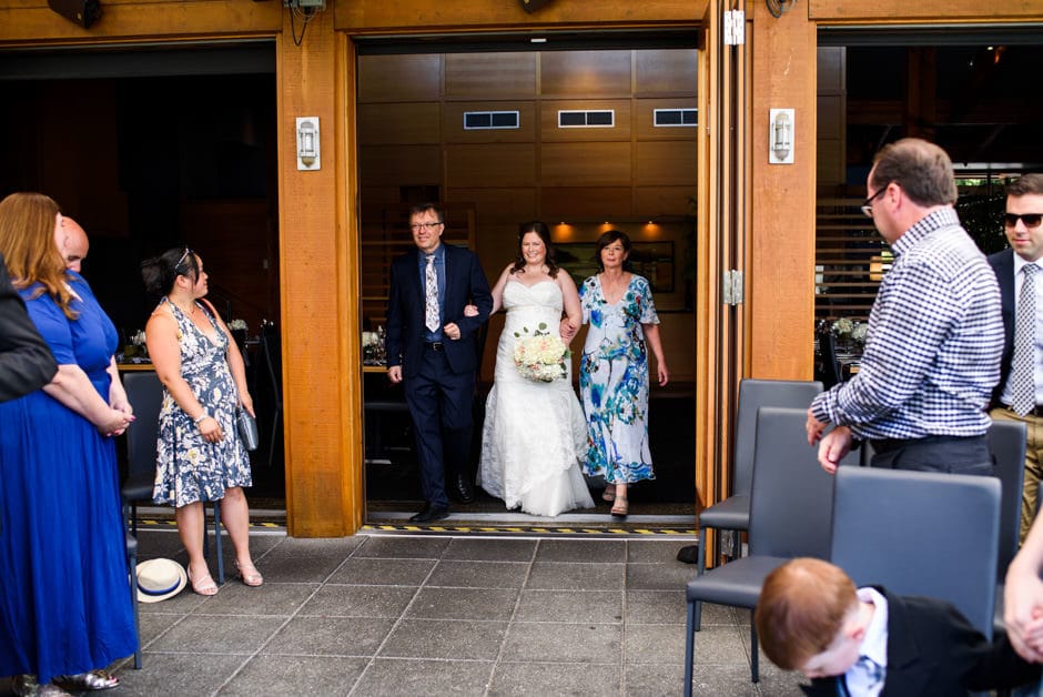 bride walking down aisle with both parents