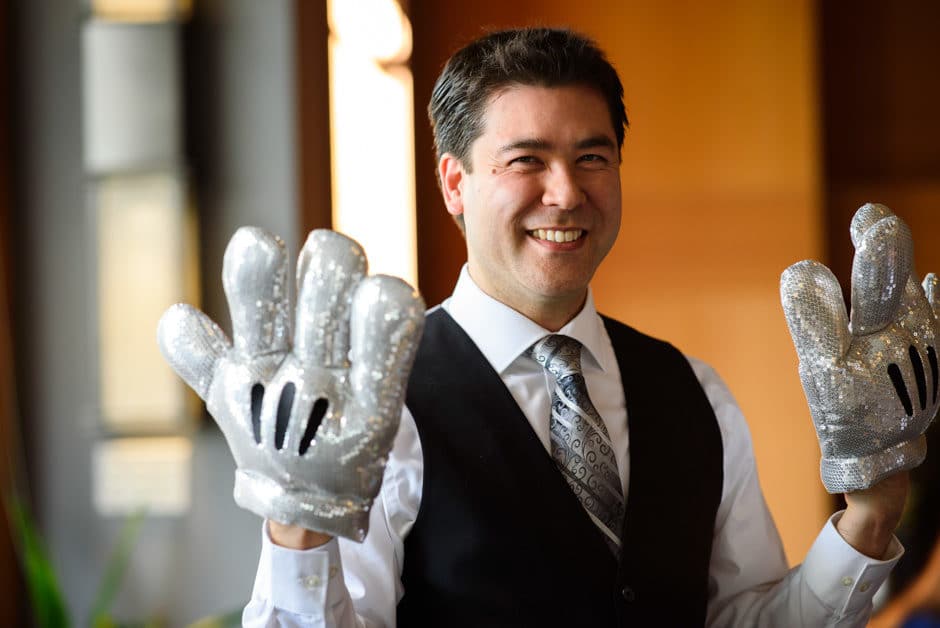 groom wearing sparkly mickey mouse gloves