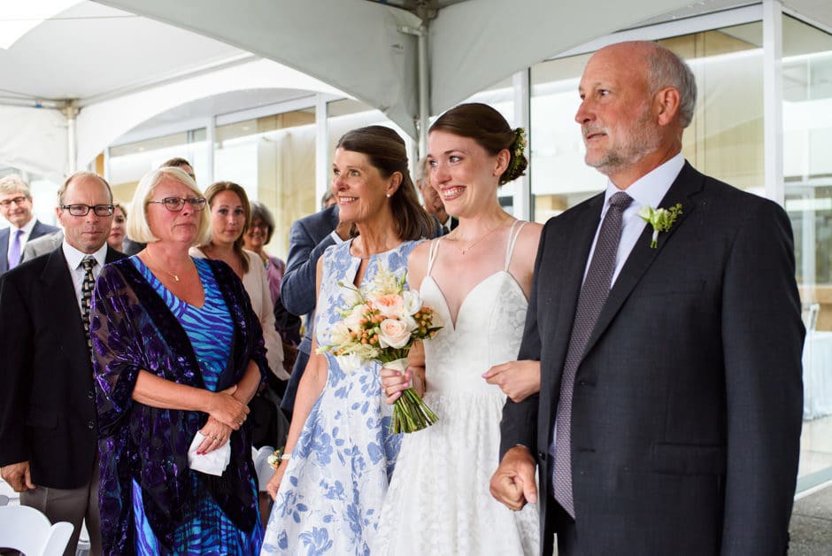 bride walking down aisle with both parents