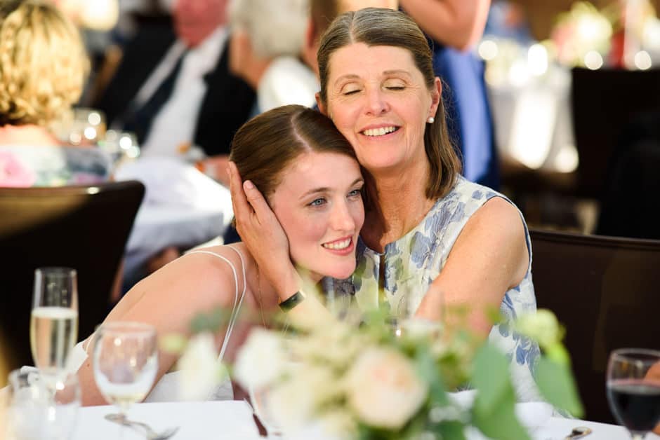 mother hugs bride during reception