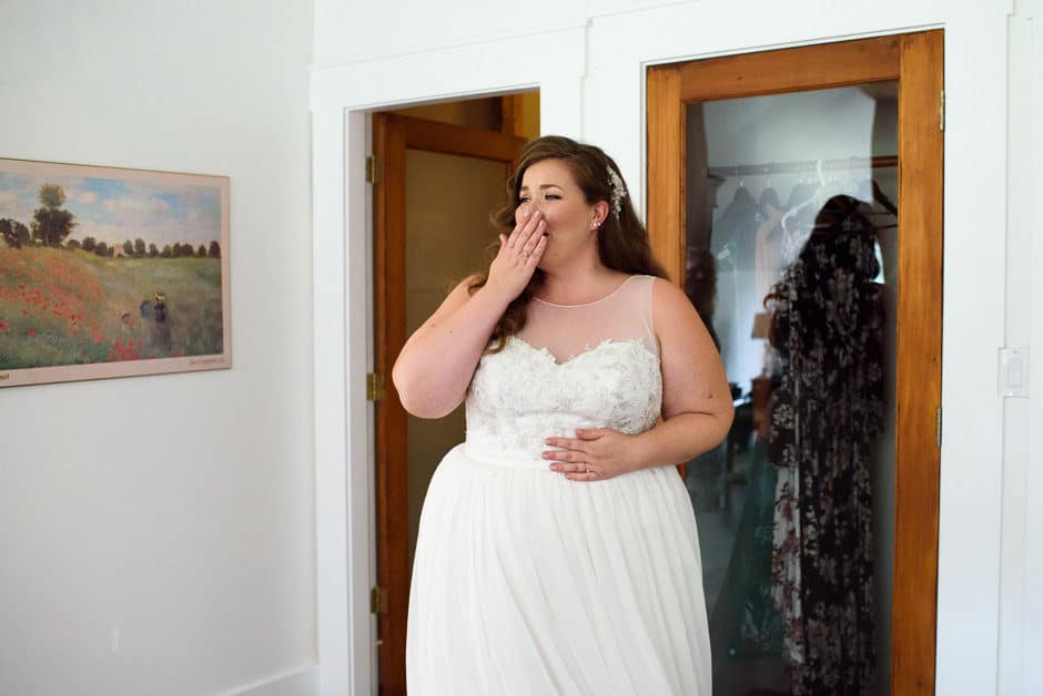 bride reacting to bridal party seeing dress
