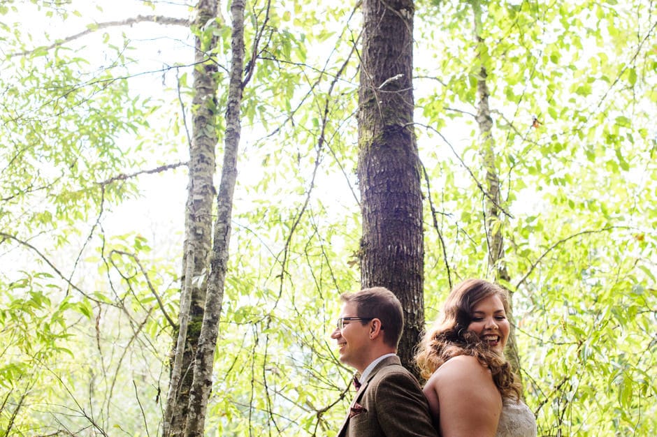 couple standing back to back during first look