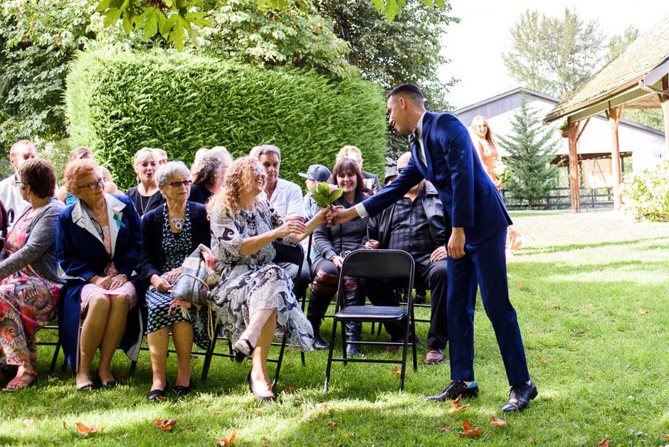 brides babe handing bouquet to mothers