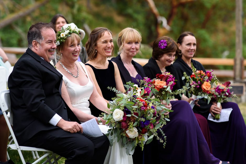 couple and wedding party listening to wedding ceremony