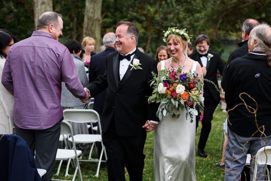 bride and groom walk down aisle