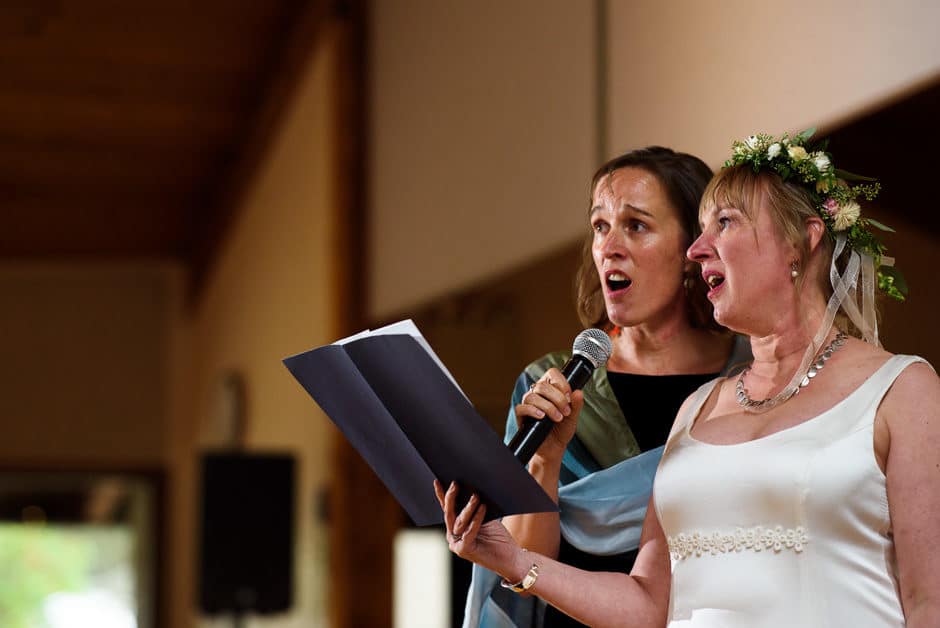 bride and sister singing at wedding reception