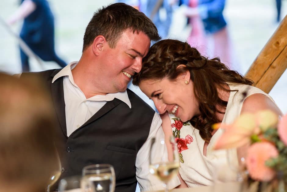 bride and groom cuddling during toasts