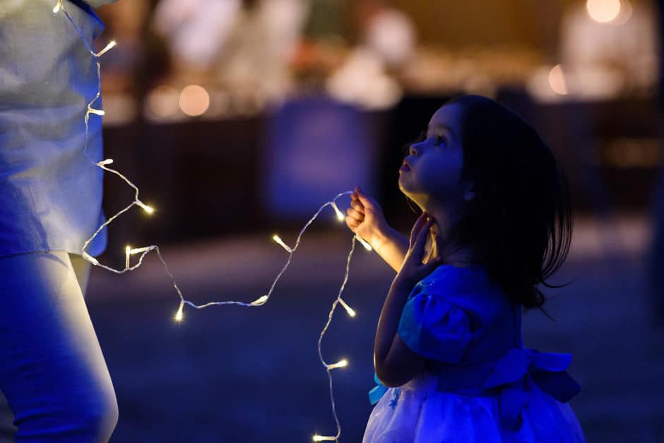 little girl playing with christmas lights