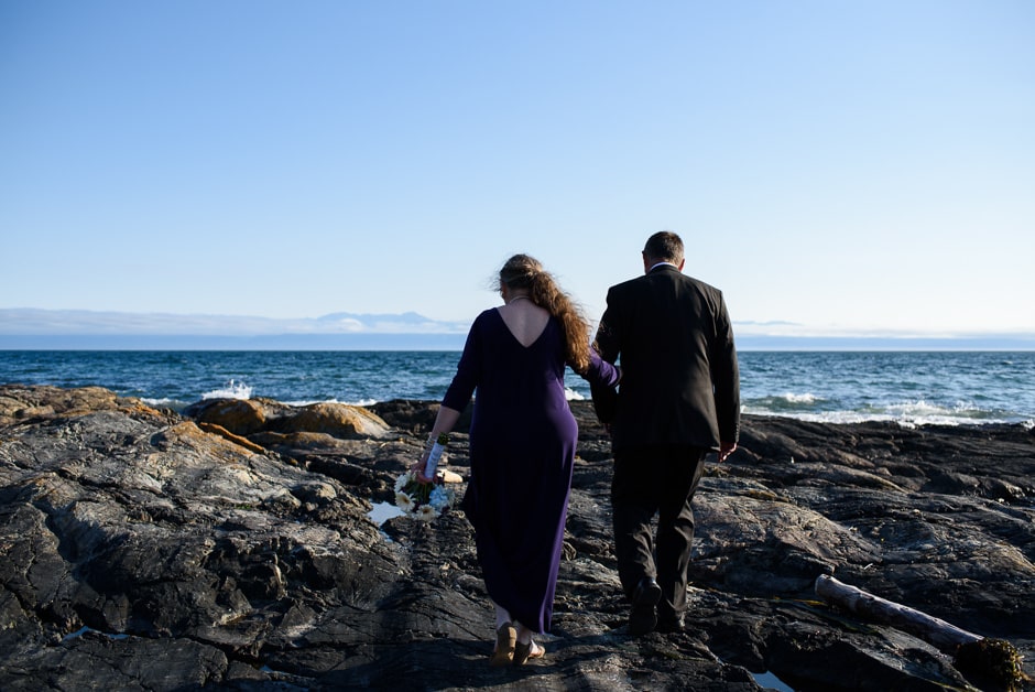 couple walking on rocks at ross bay beach
