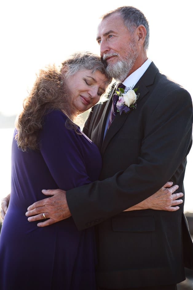 older married couple embracing at ross bay beach