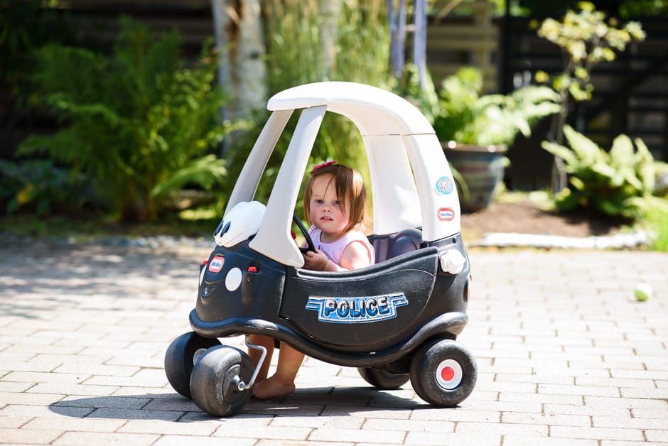 little girl in toy police car