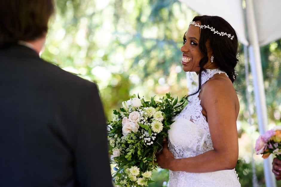 bride giving flirty look to groom during wedding ceremony