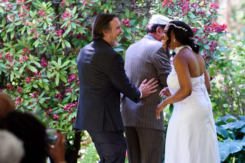 couple wiping hands on officiant after water ceremony